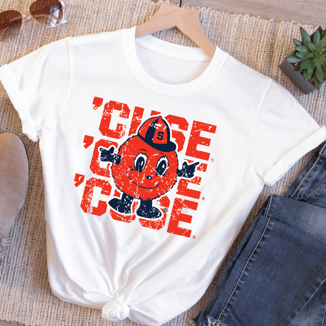 Flatlay of white t-shirt with bold distressed triple ’CUSE text and full-color Otto the Orange mascot – styled with jeans and accessories for game day