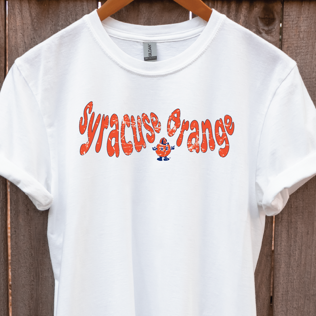 White t-shirt hanging on wood backdrop featuring retro “Syracuse Orange” text in bold orange with Otto the Orange mascot – Citrus Styles collegiate merch