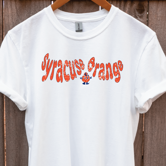 White t-shirt hanging on wood backdrop featuring retro “Syracuse Orange” text in bold orange with Otto the Orange mascot – Citrus Styles collegiate merch