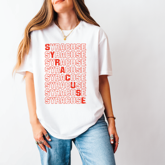Model wearing white unisex t-shirt with bold red stacked “Syracuse” distressed graphic, styled with jeans and gold jewelry – Citrus Styles licensed SU apparel


